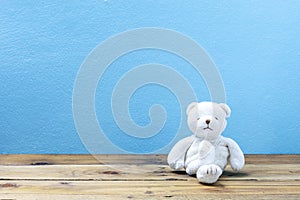 Teddy bear on old wood ,blue wall background