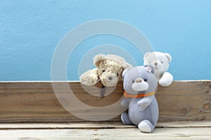 Teddy bear on old wood ,blue wall background