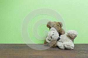 Teddy bear on old wood in front green background.