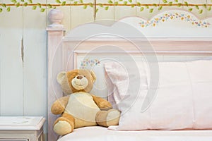 Teddy bear on a pink bed