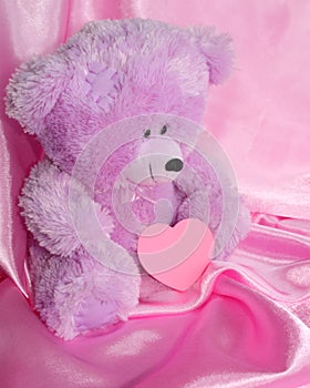 Teddy Bear and pink heart on purple - stock photos