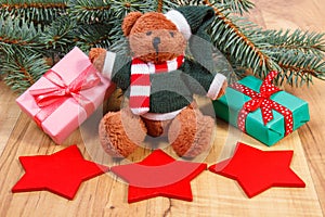Teddy bear with red star and gifts for Christmas, spruce branches