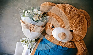 Teddy bear with roses and orchid.