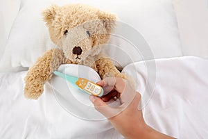 Teddy Bear is sick in bed on white background