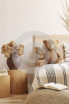 Teddy bear on single bed in natural kid`s room