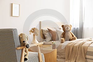 Teddy bear on single wooden bed in natural kid`s bedroom