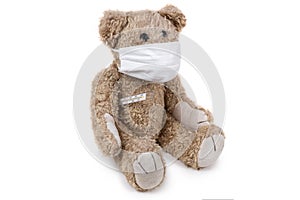 The teddy bear sits ill with a coronavirus in a medical mask