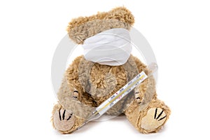 The teddy bear sits ill with a coronavirus in a medical mask