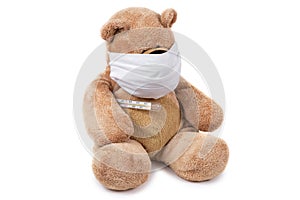 The teddy bear sits ill with a coronavirus in a medical mask