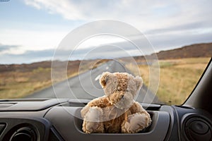 Teddy bear, sitting on the front windshield of a camper van, people traveling in Iceland, camping