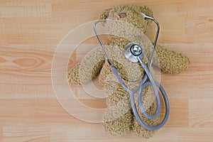 Teddy bear with stethoscope, acoustic medical device with earpieces in ears . photo