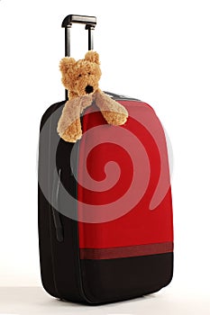 Teddy bear on a suitcase with long handle