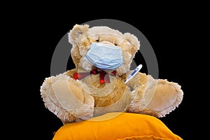 Brown teddy bear in medical mask with thermometer. coronavirus, covid 19 protection concept. quarantine and child safety problem