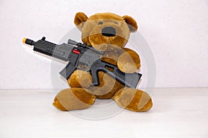 Teddy bear with toy gun. the concept of war, child safety, terrorism, to protect children from armed attack, weapons ban, the