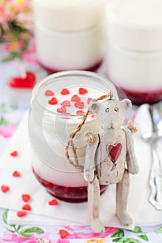 Teddy Bear Toy Leaning over a Jar of Yoghurt with Raspberry Jam