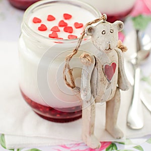 Teddy Bear Toy Leaning over a Jar of Yoghurt with Raspberry Jam