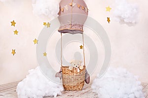 Teddy bear traveler and pilot. Childhood dreams. Stylish vintage children`s room with aerostat, balloons and textile clouds. Child