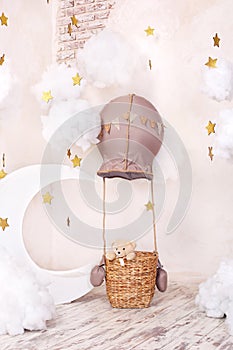 Teddy bear traveler and pilot. Childhood dreams. Stylish vintage children`s room with aerostat, balloons, textile clouds and the m