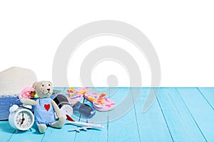 Teddy bear with white alarm clock,Beach accessory,hat,sunglasses,shoes on blue wooden plank background, concept summer holiday ba