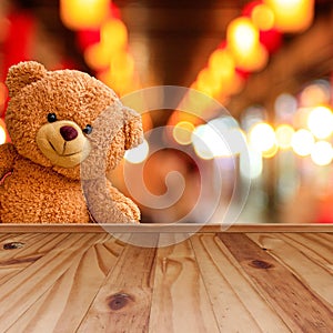 Teddy bear on wooden floor and blurred background photo