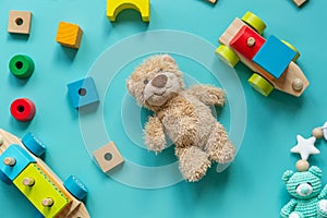 Teddy bear, wooden toys, blocks for preschooler children on a blue background. Toys for kindergarten, preschool or daycare.