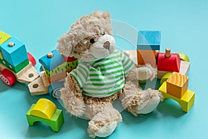 Teddy bear, wooden toys, blocks for preschooler children on a blue background. Toys for kindergarten, preschool or daycare.