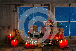 Teddy bears and red candles decorated on an old windowsill background.