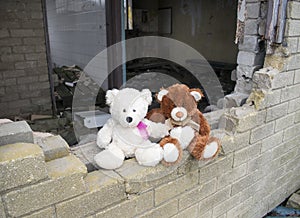 Teddy Bears Sitting On Smashed Derelict Abandoned Building Wall