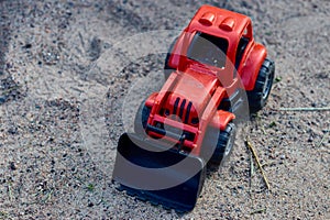 Teddy red tractor in the sand. Kids toys. toy concept for children. copy space