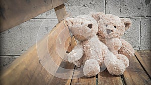 Teddybears sitting on a bench in the park