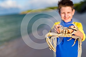 Teen age boy holding crab