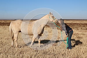 Teen-age girl showing some love to her horse in open field