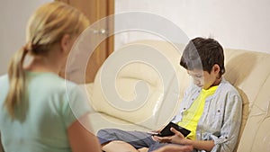 Teen age son playing with phone, mother trying to talk