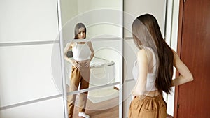 Teen anorexia, bulemia, skinny teen girl looks in the mirror and sees herself fat