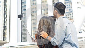 teen asia people use smart phone to selfie, self-portrait photography shoot, held in the hand and supported by a selfie stick