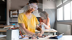 Teen asian girl high school student in class learning electronics looking at camera. Horizontal banner image. Copy space