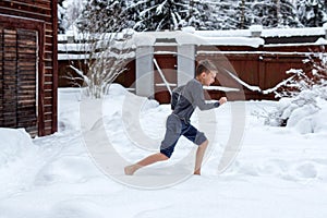 Teen barefoot runs in the snow. Winter day. Hardening