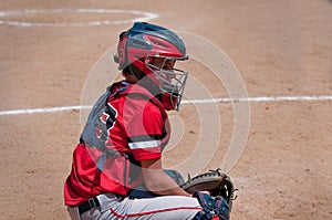 Teen baseball catcher behind home plate.