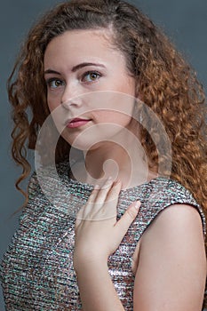 Teen beauty in head shot in green dress resting hand.