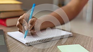 Teen black girl writing notes in notebook