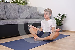 Teen blond boy exercising sport at home practice yoga sit in pose keep calm meditating Healhty lifestyle