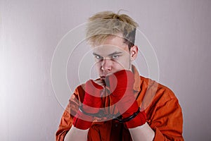 Teen boxer in handcuffs on a gray background.Concept: athletes are hooligans. Juvenile delinquent, criminal liability of minors. M