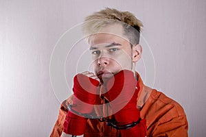 Teen boxer in handcuffs on a gray background.Concept: athletes are hooligans. Juvenile delinquent, criminal liability of minors. M