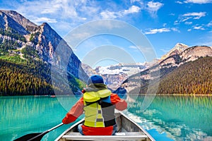 Teen boy canoeing on Lake Louise in Banff National Park of the Canadian Rockies with its glacier-fed turquoise lakes and Mount