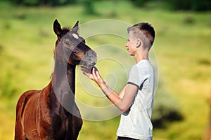 Teen boy communicates with horse photo