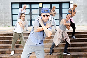 Teen boy dancing modern street dance with teenagers