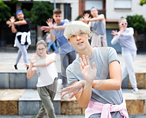 Teen boy dancing modern street dance with teenagers