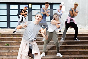 Teen boy dancing modern street dance with teenagers