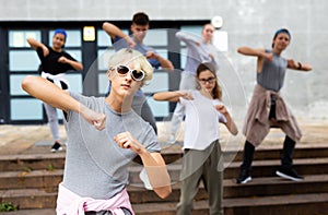 Teen boy dancing modern street dance with teenagers