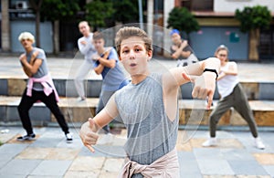 Teen boy dancing modern street dance with teenagers